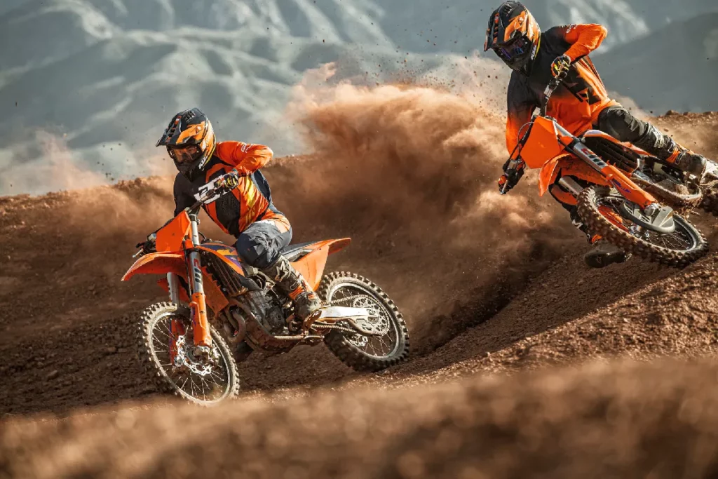 Zwei Fahrer in einer Kurve auf 2026 KTM 450 SX-F und KTM 250 SX-F 4-Takt Motocross-Bikes.