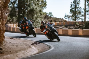 Zwei Fahrer auf KTM 1390 Super Adventure S EVO in schneller Kurve auf der Straße