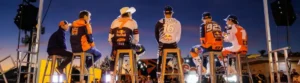 Red Bull KTM Factory Racing Teammitglieder auf der Bühne bei Dämmerung.